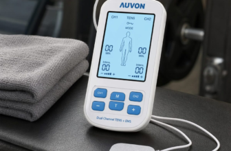 AUVON Dual Channel TENS EMS unit with blue LCD screen and electrode pads on gym bench