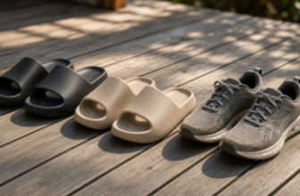 Recovery slides lined up next to worn running shoes on a wooden deck